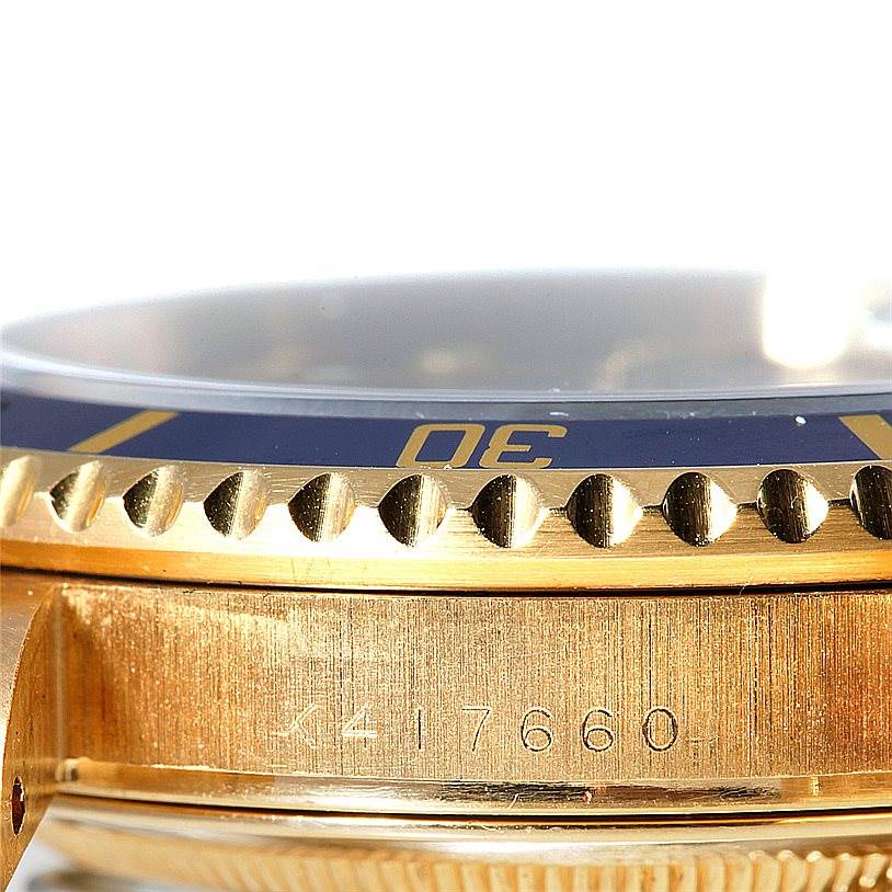 This image shows a close-up side view of the bezel and part of the case of a Rolex Submariner 16618 Men's Yellow Gold Grey Dial 16618 Men's Yellow Gold Grey Dial watch.