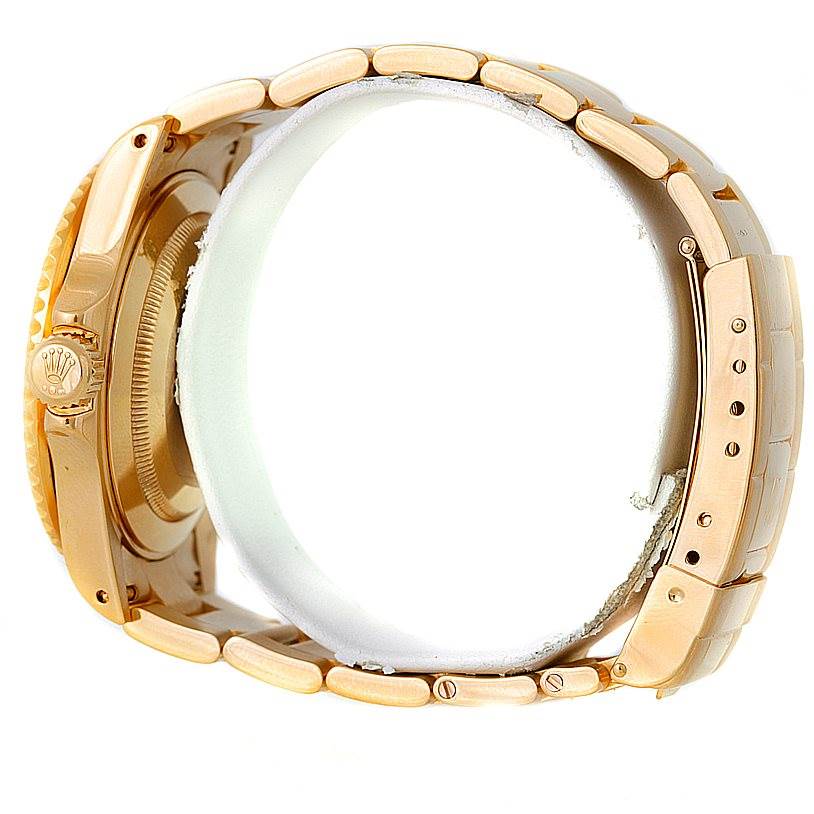 This is a side view of the Rolex Submariner 16618 Men's Yellow Gold Grey Dial 16618 Men's Yellow Gold Grey Dial watch showing the bracelet, clasp, crown, and part of the case.