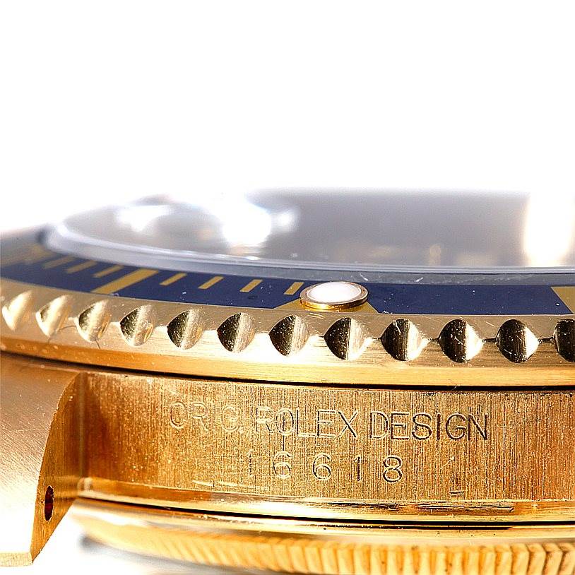 This image shows a close-up side view of the bezel and case of a Rolex Submariner 16618 Men's Yellow Gold Grey Dial 16618 Men's Yellow Gold Grey Dial watch, highlighting its engravings and design details.