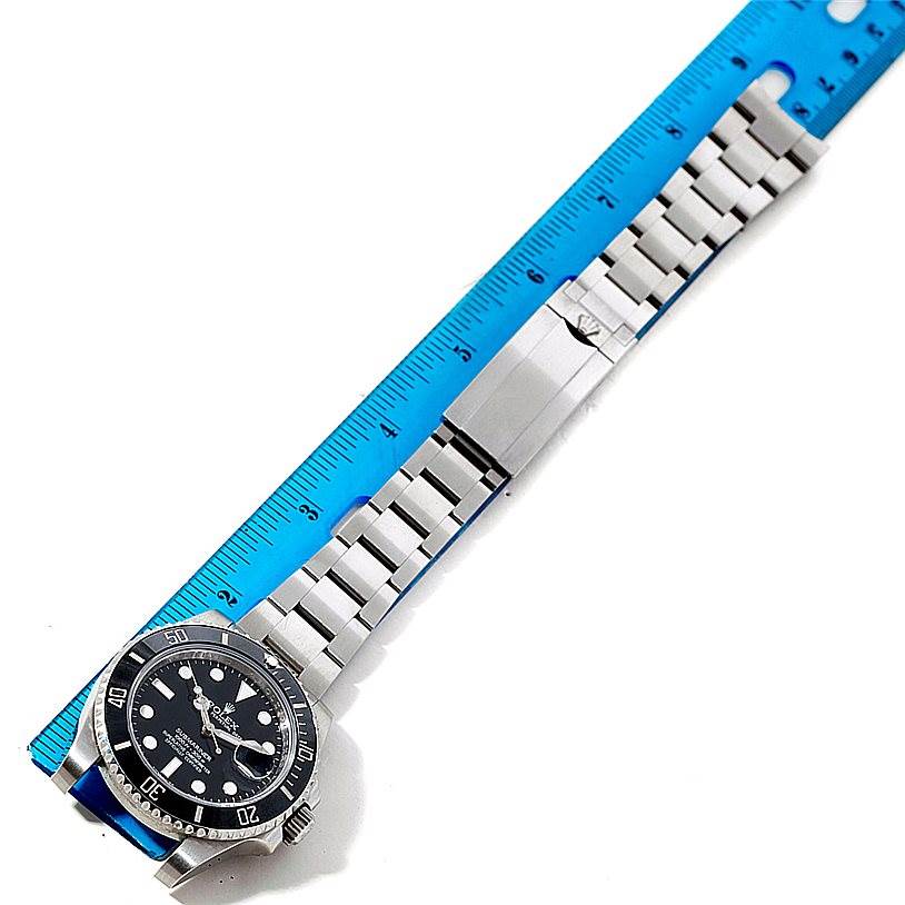 The image shows a Rolex Submariner 116610 Men
s Stainless Steel Black Dial 116610 Men
s Stainless Steel Black Dial watch laid flat with a blue ruler for scale, highlighting the bracelet length and clasp.