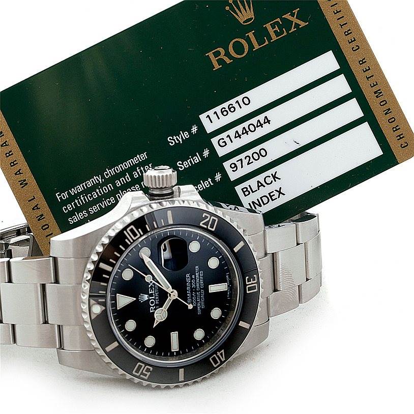 The image shows a Rolex Submariner 116610 Men
s Stainless Steel Black Dial 116610 Men
s Stainless Steel Black Dial watch from a front angle, along with its warranty card.
