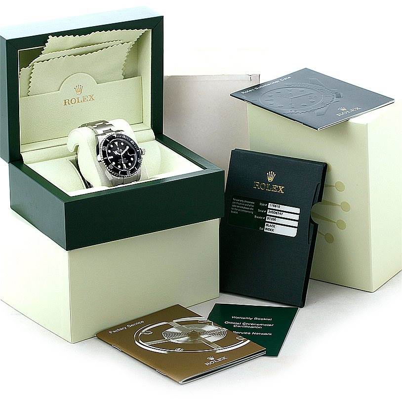 The Rolex Submariner 116610 Men
s Stainless Steel Black Dial 116610 Men
s Stainless Steel Black Dial watch is shown in its box, with manuals, warranty card, and packaging around it.