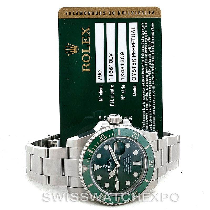 The image shows a Rolex Submariner 116610LV Men's Stainless Steel Green Dial 116610LV Men's Stainless Steel Green Dial watch with a green dial and bezel, placed in front of its authentication card.