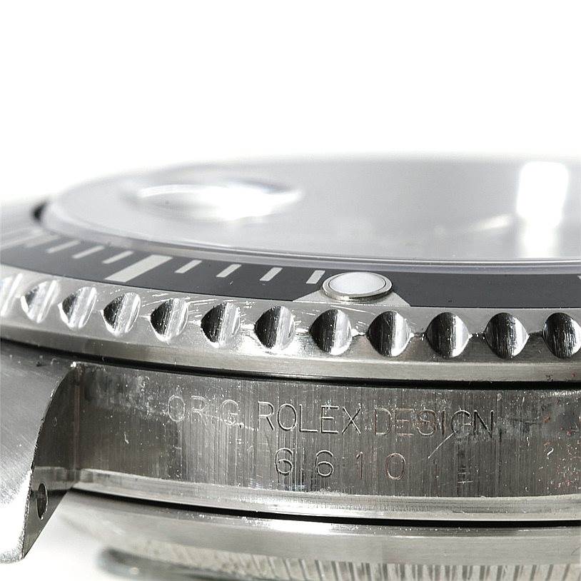 Close-up side angle of the Rolex Submariner 16610 Men
s Stainless Steel Black Dial 16610 Men
s Stainless Steel Black Dial watch showing the bezel, part of the crystal, and the engraving on the case.