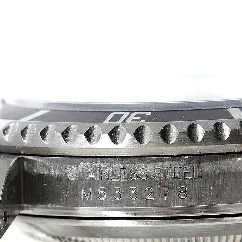 This close-up image of a Rolex Submariner 16610 Men
s Stainless Steel Black Dial 16610 Men
s Stainless Steel Black Dial watch shows the side of the case with part of the bezel and the engraved serial number.