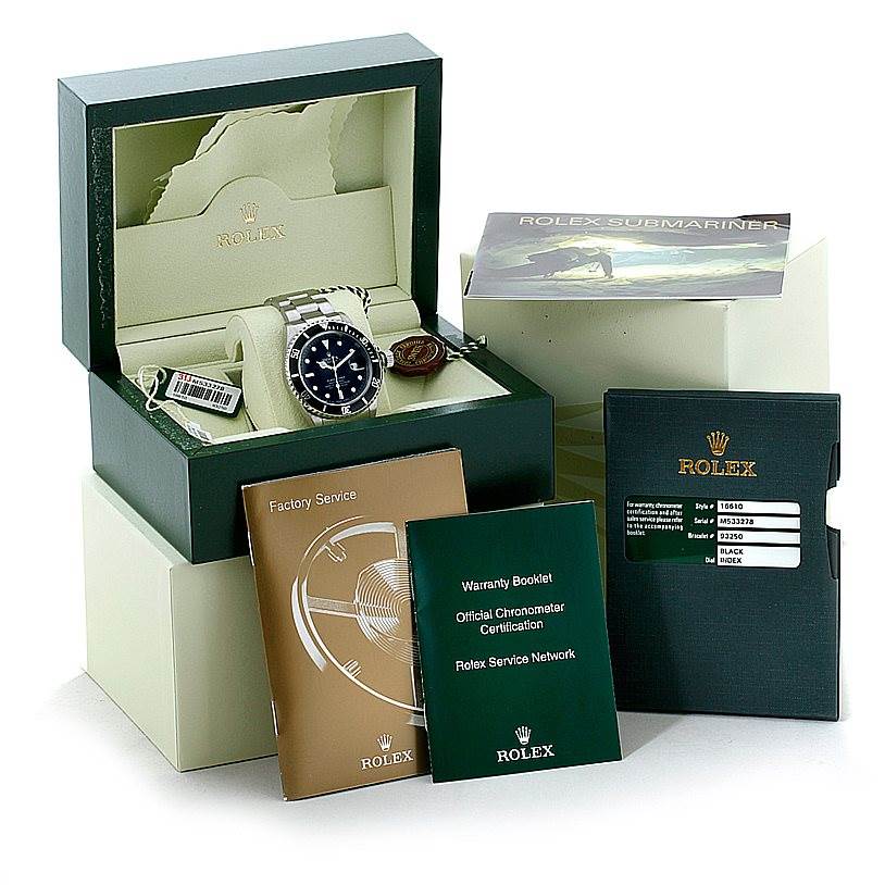 The image showcases a Rolex Submariner 16610 Men
s Stainless Steel Black Dial 16610 Men
s Stainless Steel Black Dial, its box, and accessories including booklets and tags.