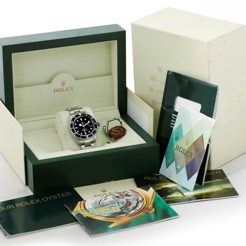 The image shows a Rolex Submariner 16610 Men
s Stainless Steel Black Dial 16610 Men
s Stainless Steel Black Dial watch in its box with accompanying booklets and tags at an angled view.