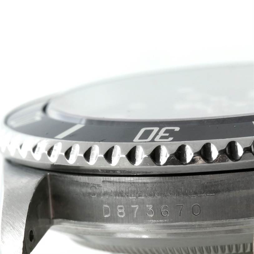 The image shows a close-up side view of the bezel and case of a Rolex Submariner 16610 Men
s Stainless Steel Black Dial 16610 Men
s Stainless Steel Black Dial, with the serial number partially visible.