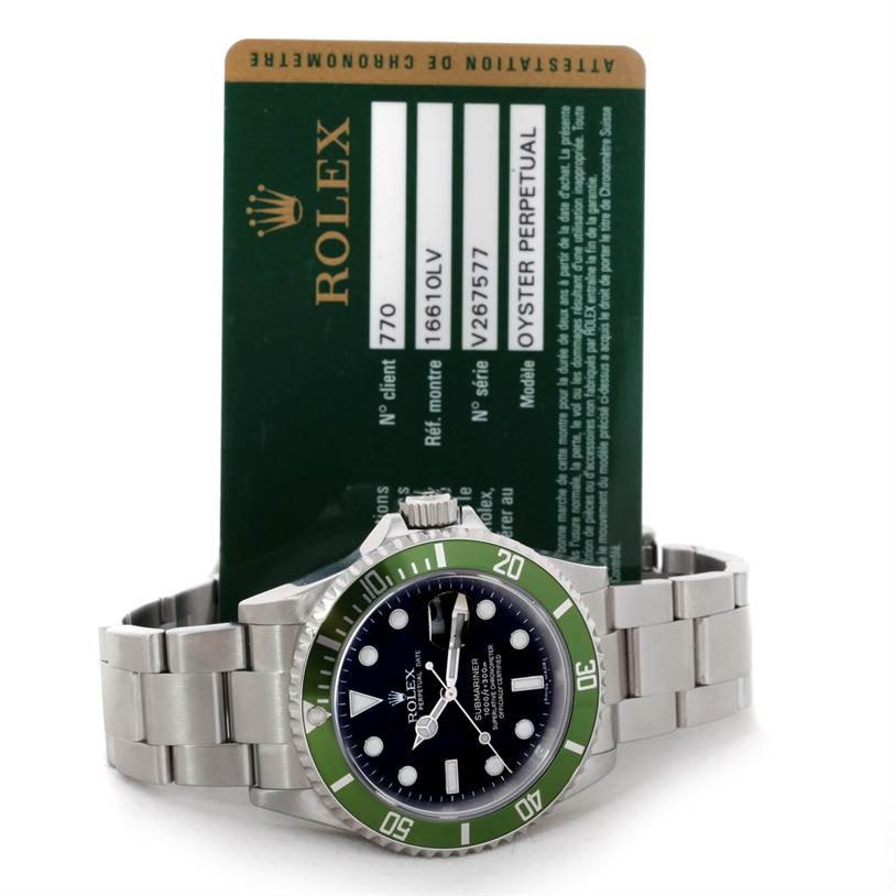 The image shows a Rolex Submariner 16610 Men
s Stainless Steel Black Dial 16610 Men
s Stainless Steel Black Dial watch and its warranty card from a front angle.