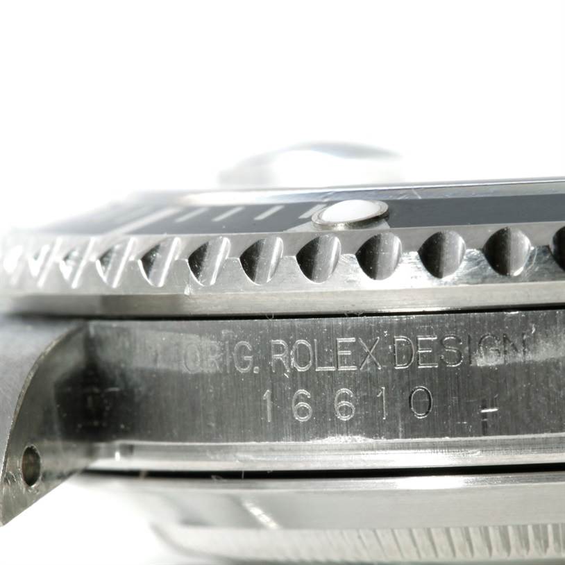 The image shows a close-up of the case side and bezel of a Rolex Submariner 16610 Men
s Stainless Steel Black Dial 16610 Men
s Stainless Steel Black Dial model 16610, focusing on the engravings and edge details.