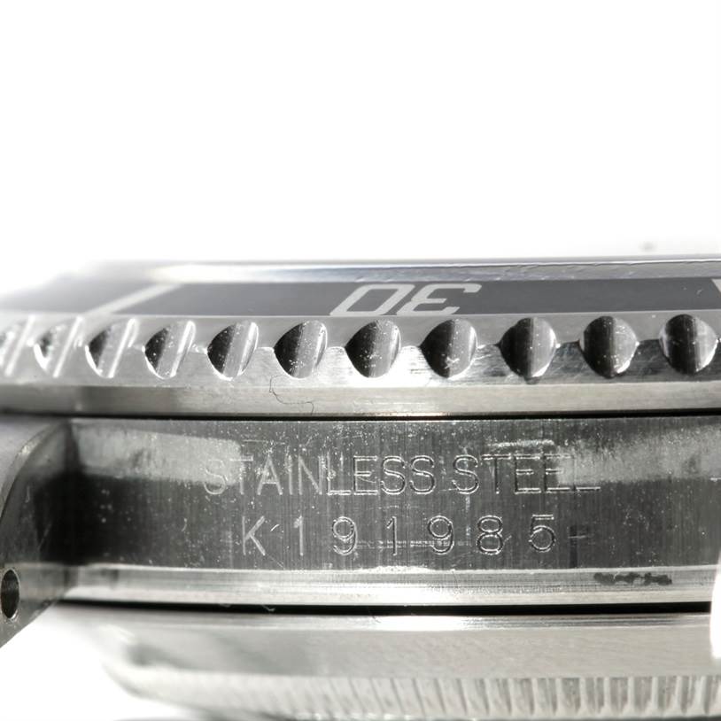 The image shows a close-up side view of a Rolex Submariner 16610 Men
s Stainless Steel Black Dial 16610 Men
s Stainless Steel Black Dial watch, highlighting the stainless steel case with engravings and the bezel.