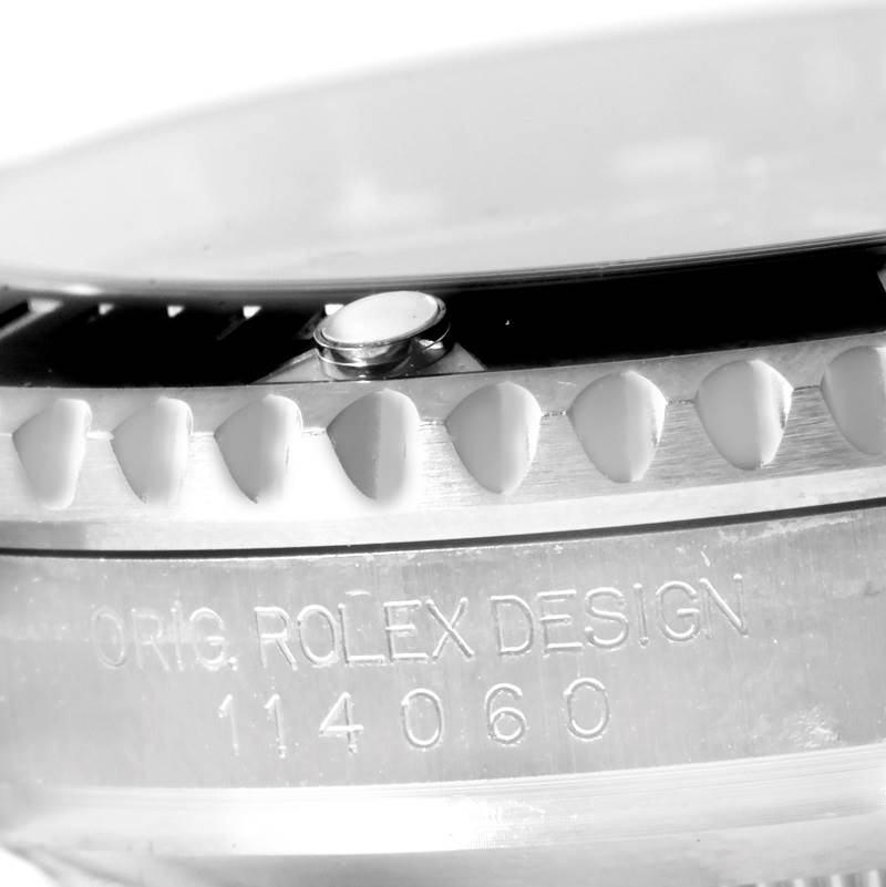 The image shows a close-up of the side of a Rolex Submariner 114060 Men
s Stainless Steel Black Dial 114060 Men
s Stainless Steel Black Dial, highlighting the bezel and engraved model number.