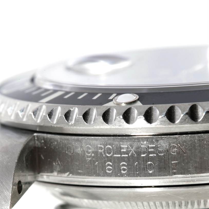 This close-up angle of a Rolex Submariner 16610 Men
s Stainless Steel Black Dial 16610 Men
s Stainless Steel Black Dial watch shows the engraved bezel, part of the dial, and the case.