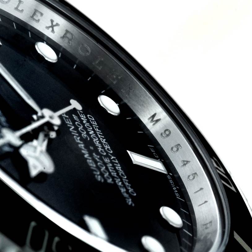 Close-up angled view of the face and rehaut of a Rolex Submariner 14060 Men
s Stainless Steel Black Dial 14060 Men
s Stainless Steel Black Dial watch, with visible text and part of the serial number.