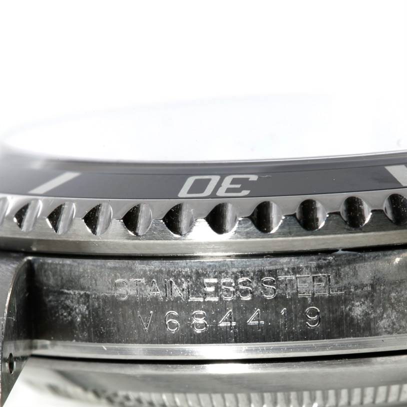The image shows a close-up side view of the bezel and case of a Rolex Submariner 16610 Men
s Stainless Steel Black Dial 16610 Men
s Stainless Steel Black Dial, including its engraved serial number.