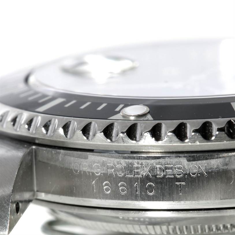 This close-up image shows the side view of the bezel and part of the casing of a Rolex Submariner 16610 Men
s Stainless Steel Black Dial 16610 Men
s Stainless Steel Black Dial model, with visible engravings.