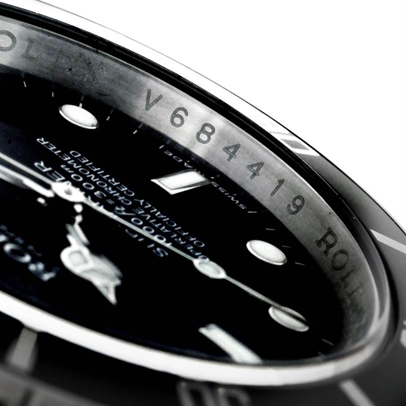 This image shows a close-up of the bezel and part of the dial of a Rolex Submariner 16610 Men
s Stainless Steel Black Dial 16610 Men
s Stainless Steel Black Dial watch, highlighting the serial number.