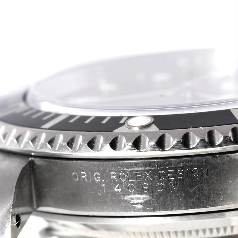 The image shows the side view of a Rolex Submariner 14060 Men
s Stainless Steel Black Dial 14060 Men
s Stainless Steel Black Dial watch case, focusing on the bezel and serial number engraving.