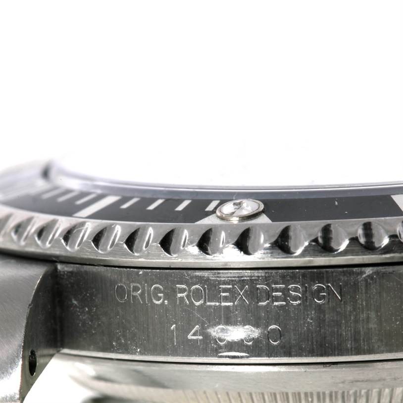 The image shows a close-up side view of a Rolex Submariner 14060 Men
s Stainless Steel Black Dial 14060 Men
s Stainless Steel Black Dial
s bezel and case with "ORIG. ROLEX DESIGN" engraved.