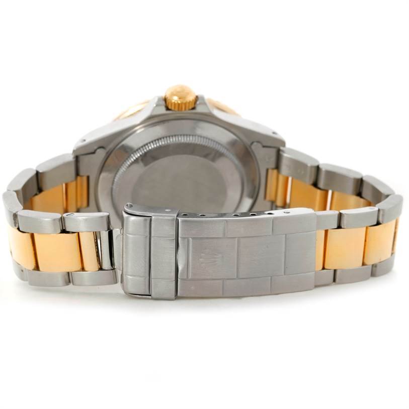 The image shows the back view of a Rolex Submariner 16803 Men's Steel and Gold (two tone) Black Dial 16803 Men's Steel and Gold (two tone) Black Dial watch, highlighting its case back, bracelet, and clasp.