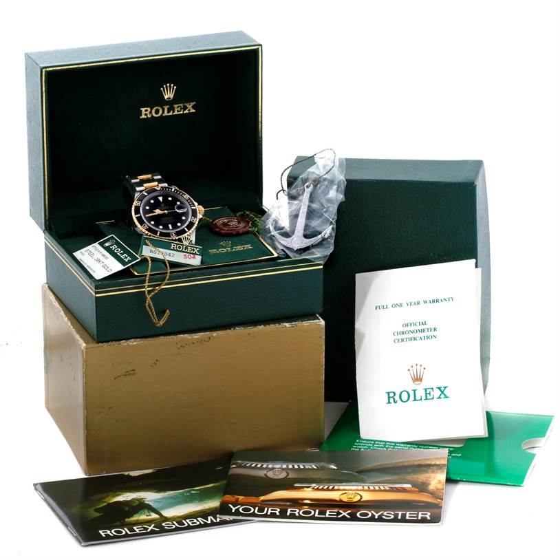 The image shows a Rolex Submariner 16803 Men's Steel and Gold (two tone) Black Dial 16803 Men's Steel and Gold (two tone) Black Dial watch in its box, accompanied by booklets, warranty card, and packaging materials.