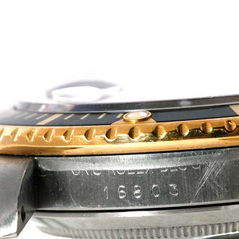 This image shows a close-up, side view of the bezel and case of a Rolex Submariner 16803 Men's Steel and Gold (two tone) Black Dial 16803 Men's Steel and Gold (two tone) Black Dial watch.
