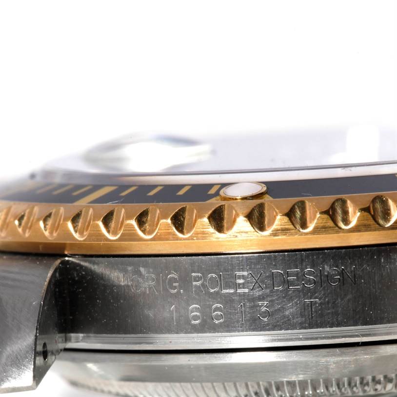This close-up angle shows the side of the Rolex Submariner 16613 Men's Steel and Gold (two tone) Black Dial 16613 Men's Steel and Gold (two tone) Black Dial model, highlighting the bezel and the engraved model number.