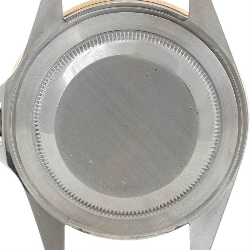 The image shows the back case of a Rolex Submariner 16613 Men's Steel and Gold (two tone) Grey Dial 16613 Men's Steel and Gold (two tone) Grey Dial watch from a top-down angle.