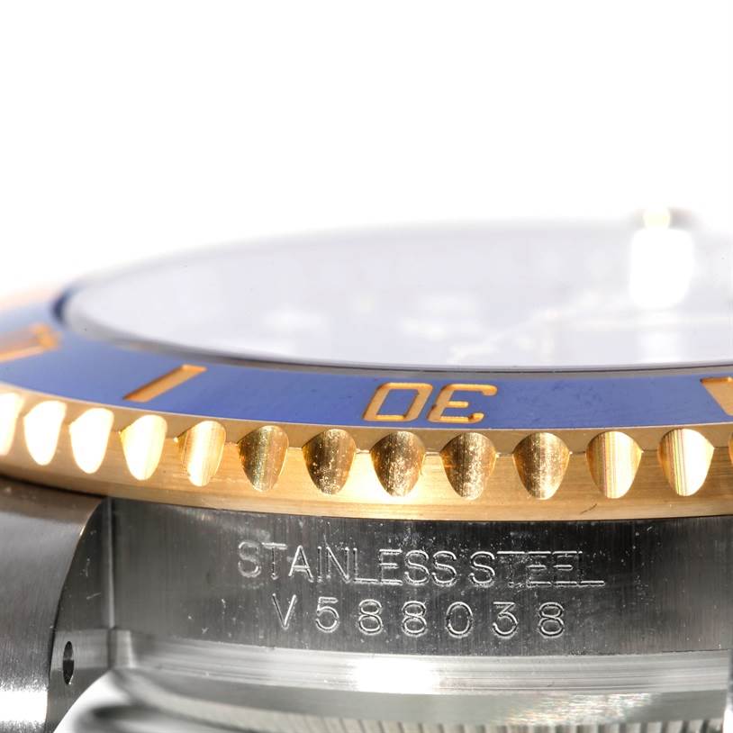 This close-up image of the Rolex Submariner 116613 Men's Steel and Gold (two tone) Blue Dial 116613 Men's Steel and Gold (two tone) Blue Dial watch shows a partial view of the bezel and side case with the serial number.