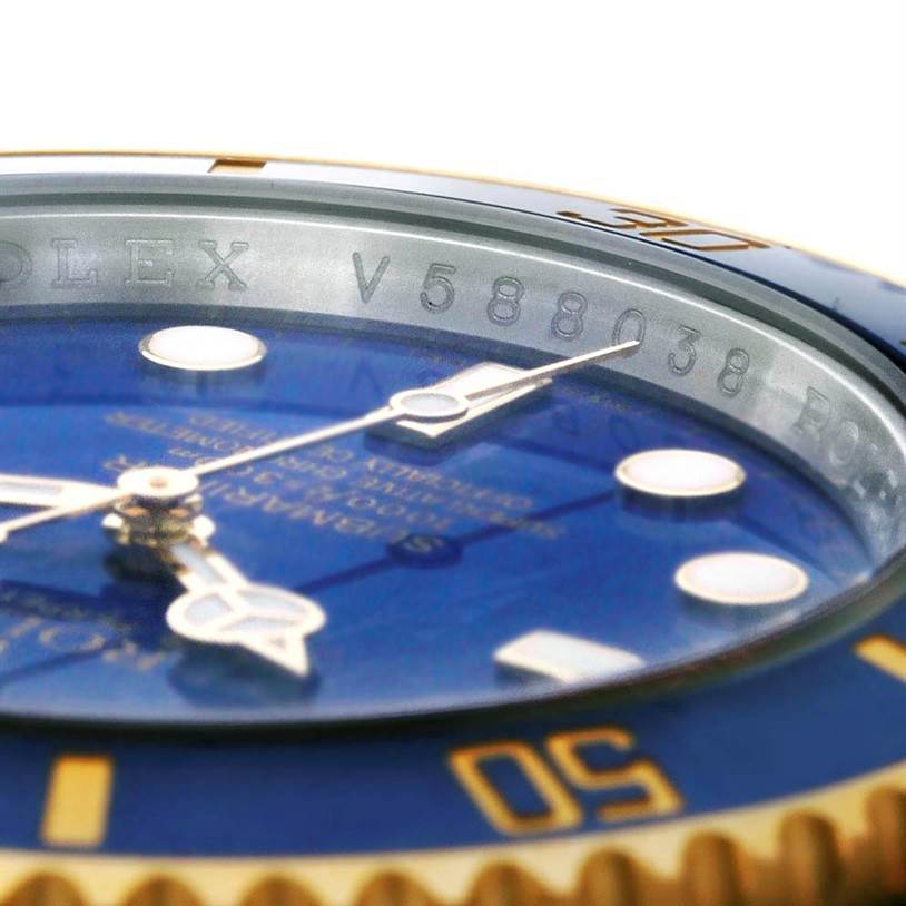 The image shows a close-up angle of the Rolex Submariner 116613 Men's Steel and Gold (two tone) Blue Dial 116613 Men's Steel and Gold (two tone) Blue Dial, focusing on the bezel and engraved serial number.