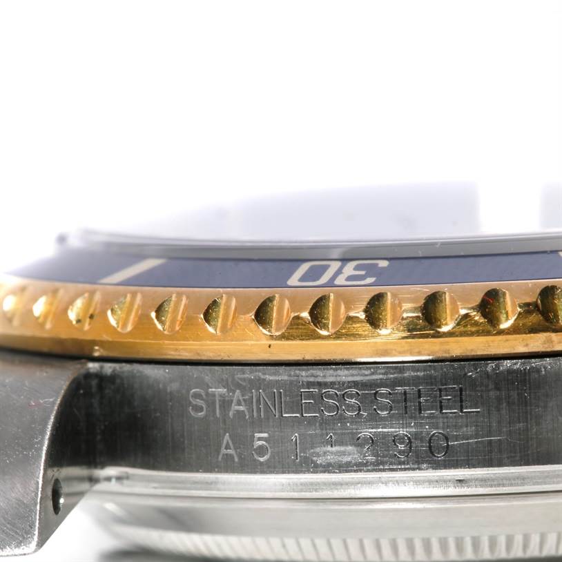 The image shows a close-up side view of a Rolex Submariner 16613 Men's Steel and Gold (two tone) Blue Dial 16613 Men's Steel and Gold (two tone) Blue Dial, highlighting the bezel, part of the case, and engraved details.