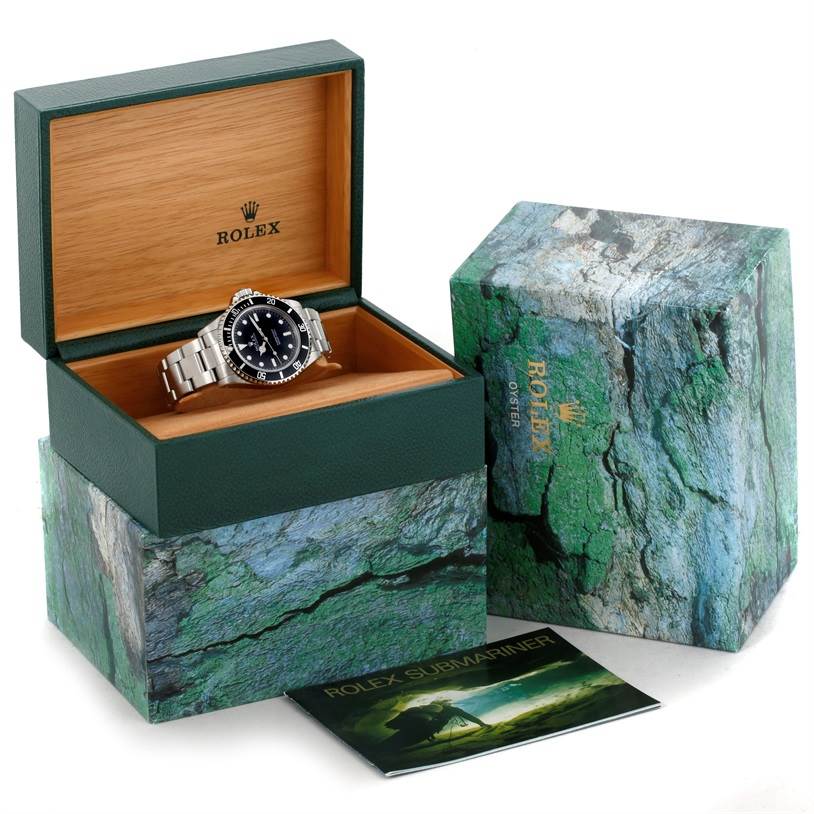 The Rolex Submariner 14060 Men
s Stainless Steel Black Dial 14060 Men
s Stainless Steel Black Dial watch is shown at a slight angle, within its open wooden box, alongside its outer box and booklet.