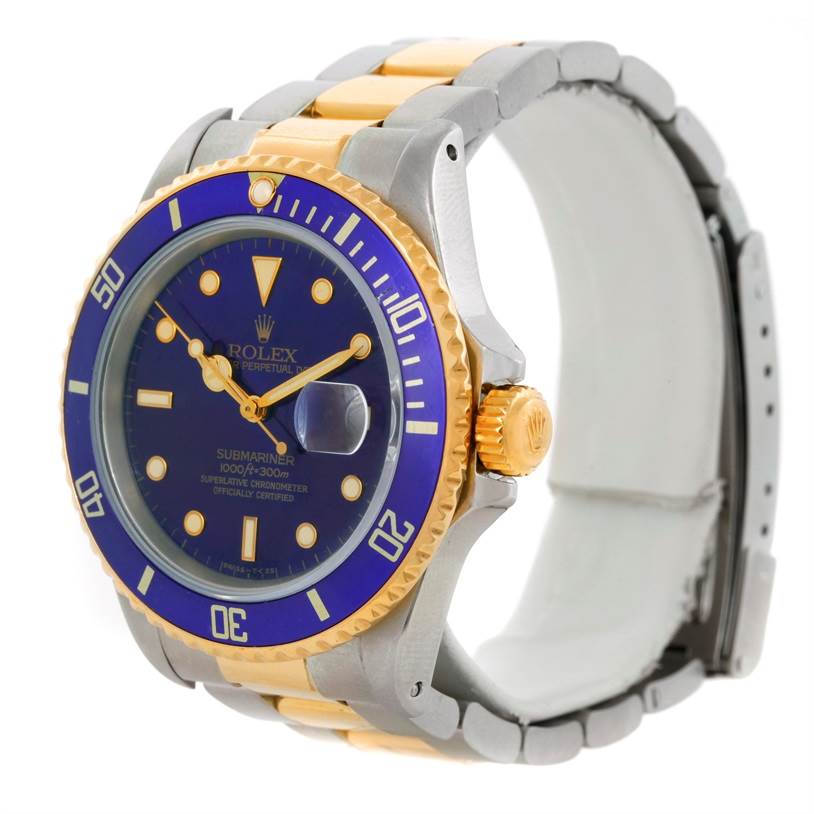 The image shows a side angle of a Rolex Submariner 16803 Men's Steel and Gold (two tone) Blue Dial 16803 Men's Steel and Gold (two tone) Blue Dial watch, highlighting its blue dial, two-tone band, and bezel.