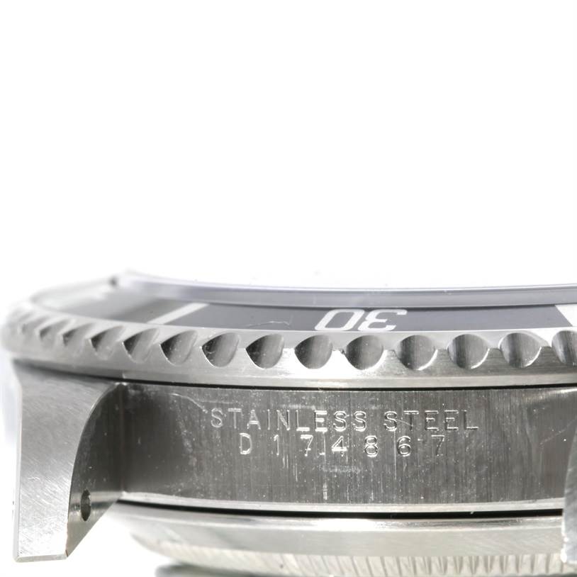 Side view of the Rolex Submariner 14060 Men
s Stainless Steel Black Dial 14060 Men
s Stainless Steel Black Dial, highlighting the bezel, part of the case, and engraved serial number.