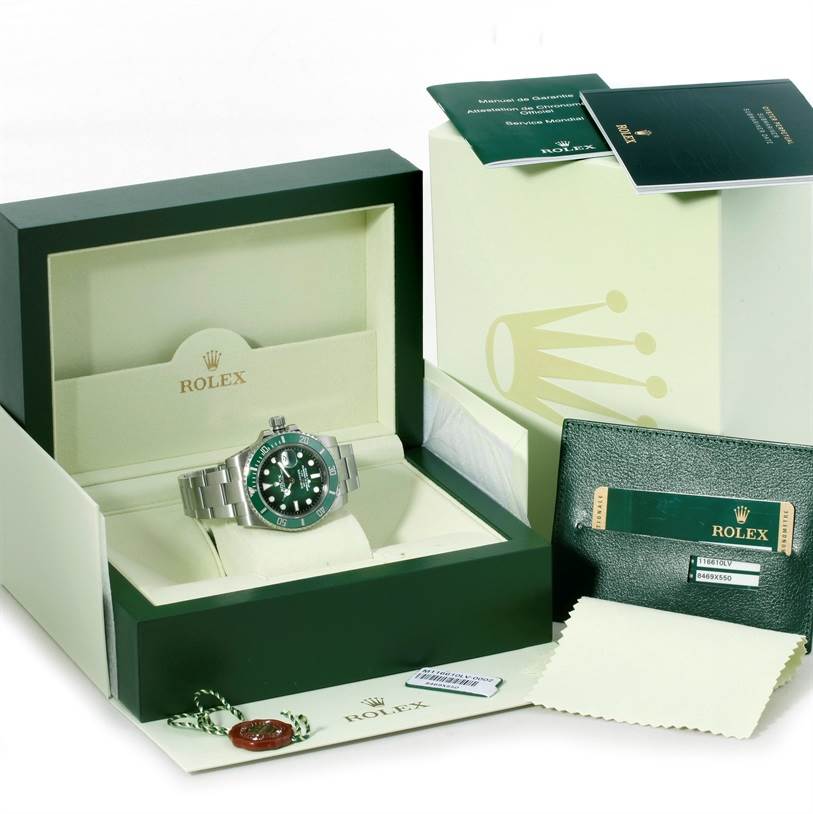 The image shows a Rolex Submariner 116610LV Men's Stainless Steel Green Dial 116610LV Men's Stainless Steel Green Dial watch in an open box, accompanied by manuals, a tag, and a cleaning cloth.
