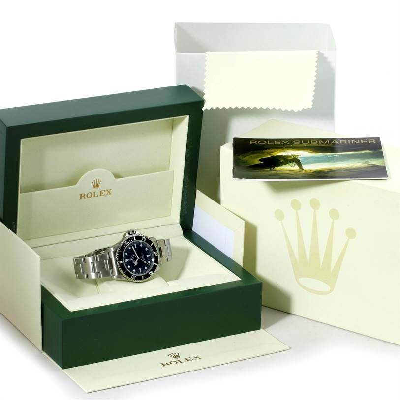The Rolex Submariner 14060 Men
s Stainless Steel Black Dial 14060 Men
s Stainless Steel Black Dial watch is displayed in its open green box along with its packaging and booklet.