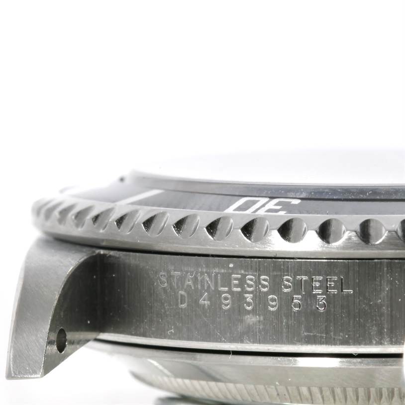 The image shows a close-up side angle of a Rolex Submariner 14060 Men
s Stainless Steel Black Dial 14060 Men
s Stainless Steel Black Dial watch, highlighting its bezel, case, and serial number.