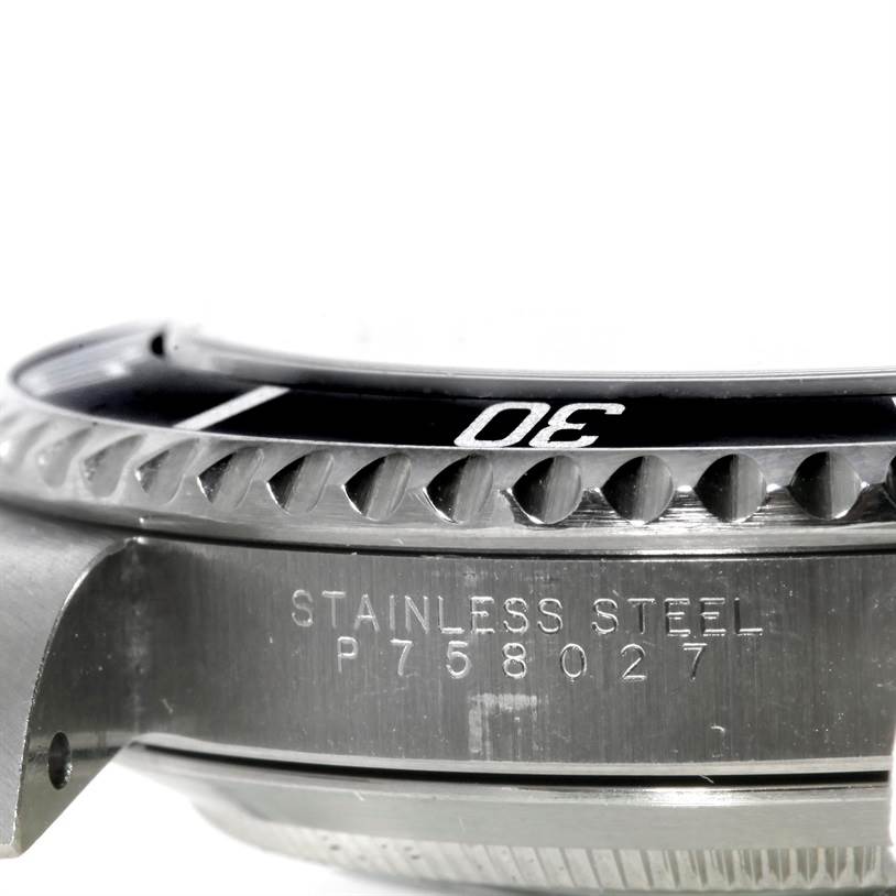The image shows a side view of a Rolex Submariner 14060 Men
s Stainless Steel Black Dial 14060 Men
s Stainless Steel Black Dial watch, focusing on its stainless steel casing and rotating bezel with engraved markings.