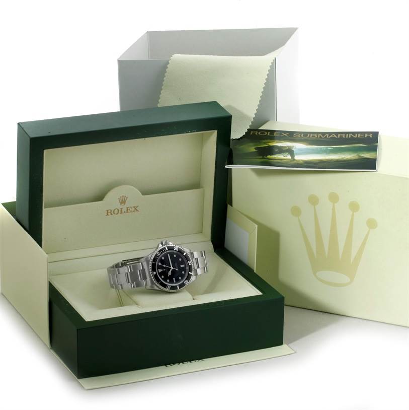 The Rolex Submariner 14060M Men
s Stainless Steel Black Dial 14060M Men
s Stainless Steel Black Dial watch is displayed in its open green and cream box, accompanied by its manual and protective cloth in the background.