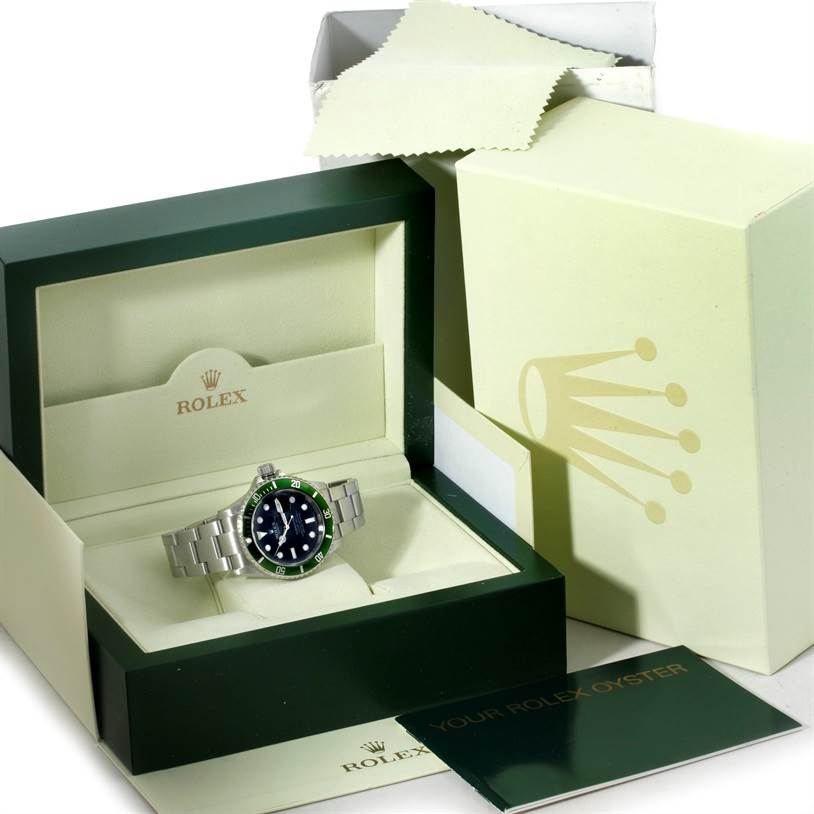 The image shows a Rolex Submariner 16610LV Men
s Stainless Steel Black Dial 16610LV Men
s Stainless Steel Black Dial watch in its open box, along with an outer box, a card, and a cloth.