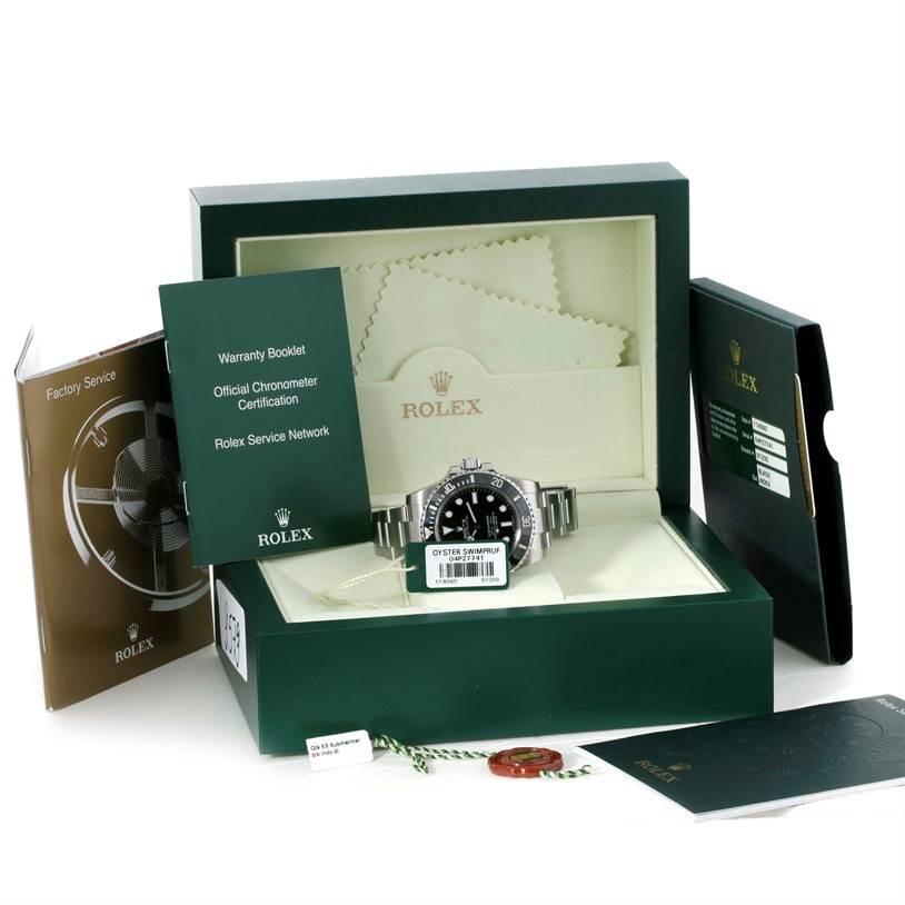 The image shows a Rolex Submariner 114060 Men
s Stainless Steel Black Dial 114060 Men
s Stainless Steel Black Dial watch in its box with various booklets and accessories, including tags and a warranty card.