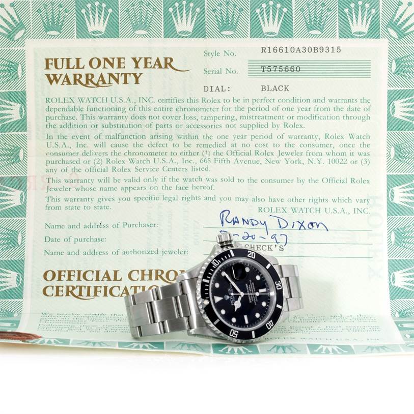 The image shows a Rolex Submariner 16610 Men
s Stainless Steel Black Dial 16610 Men
s Stainless Steel Black Dial watch placed in front of a full one year warranty document, showcasing its dial and bracelet.