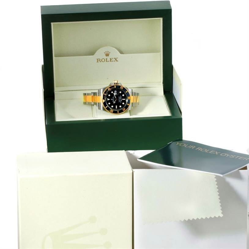 The image shows a Rolex Submariner 116613 Men's Steel and Gold (two tone) Black Dial 116613 Men's Steel and Gold (two tone) Black Dial model watch in its box, with the box lid open and the watch manuals and polishing cloth nearby.