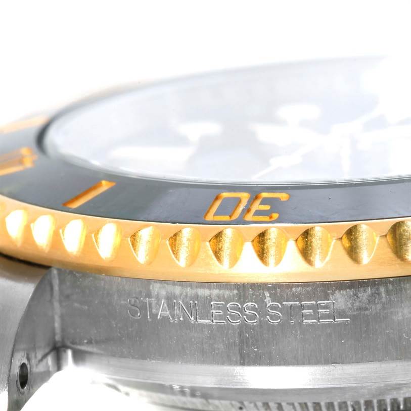 The image shows a close-up side angle of a Rolex Submariner 116613 Men's Steel and Gold (two tone) Black Dial 116613 Men's Steel and Gold (two tone) Black Dial, highlighting its bezel and case with "STAINLESS STEEL" engraved.