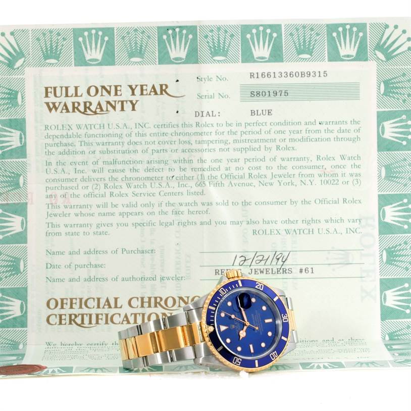 The image shows a Rolex Submariner 16613 Men's Steel and Gold (two tone) Blue Dial 16613 Men's Steel and Gold (two tone) Blue Dial watch with a blue dial and a two-tone bracelet, alongside its warranty card.