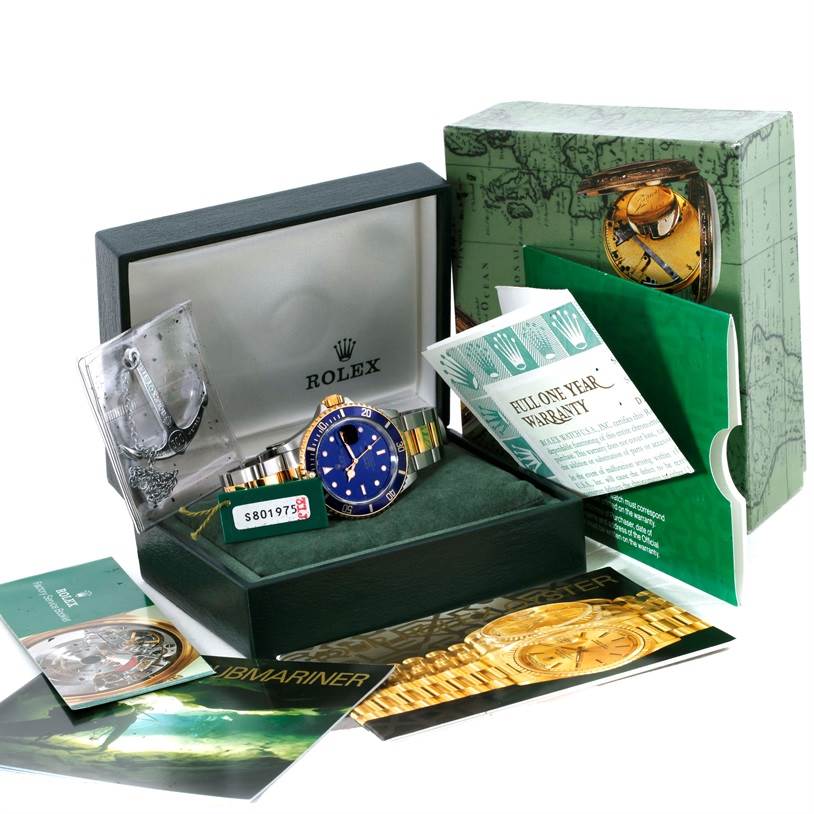 This image shows a Rolex Submariner 16613 Men's Steel and Gold (two tone) Blue Dial 16613 Men's Steel and Gold (two tone) Blue Dial watch in its box, accompanied by warranty cards, manuals, and tags.