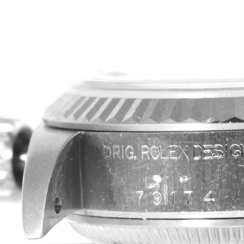 The image shows a close-up side view of the casing and bezel of a Rolex Datejust 79174 Women's Stainless Steel White Dial 79174 Women's Stainless Steel White Dial watch, with part of the brand engraving visible.