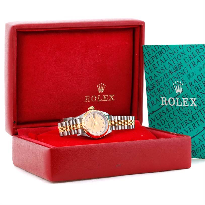 The Rolex Datejust 69173 Women's Stainless Steel Champagne Dial 69173 Women's Stainless Steel Champagne Dial watch is shown in its box with a green booklet beside it, viewed from the front.