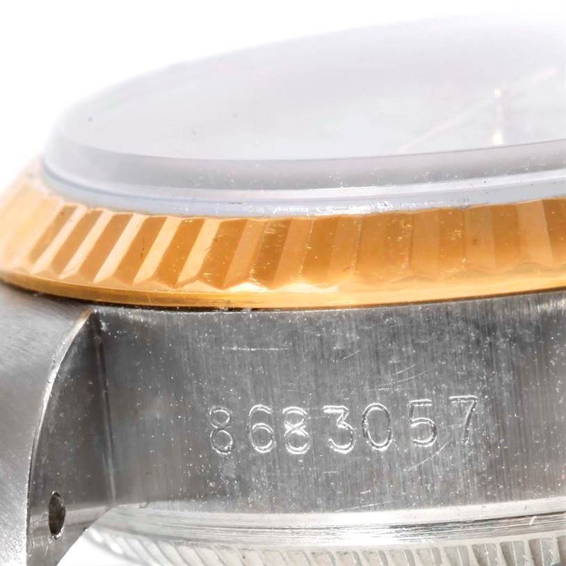This close-up of a Rolex Datejust 69173 Women's Stainless Steel White Dial 69173 Women's Stainless Steel White Dial watch shows the side of the case, the bezel, part of the crystal, and the serial number.