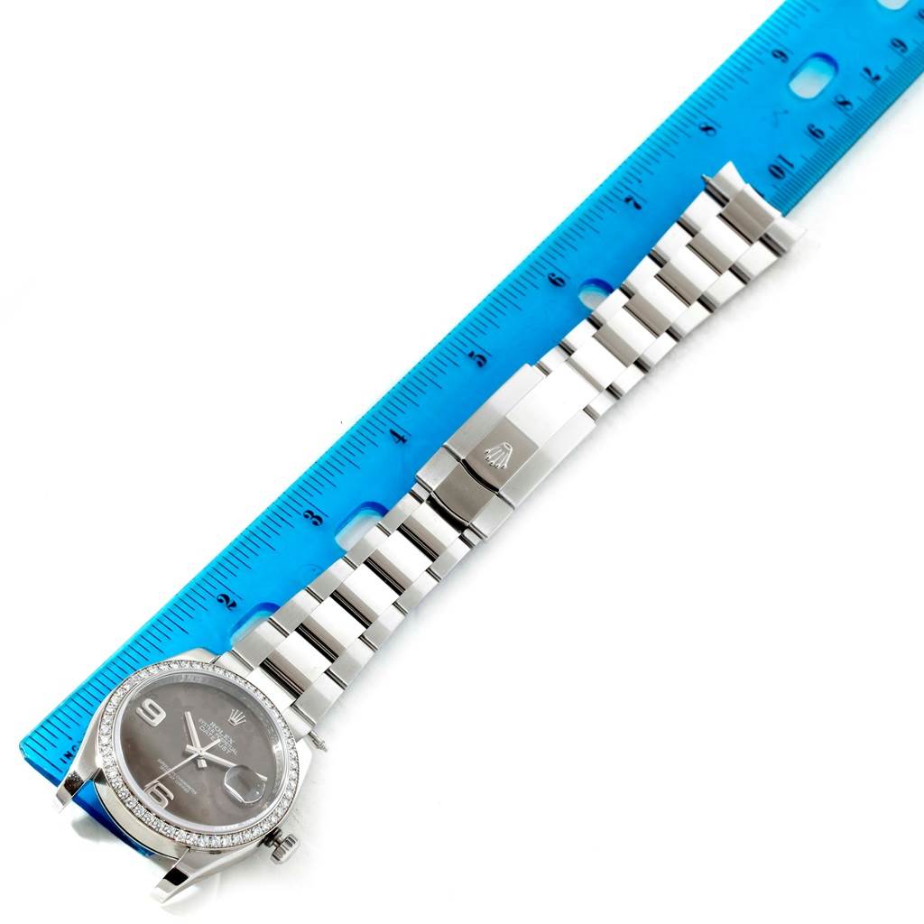 This image shows the face, bezel, and bracelet of a Rolex Datejust 116244 Men's Stainless Steel Brown Dial 116244 Men's Stainless Steel Brown Dial watch, laid alongside a blue ruler for scale.